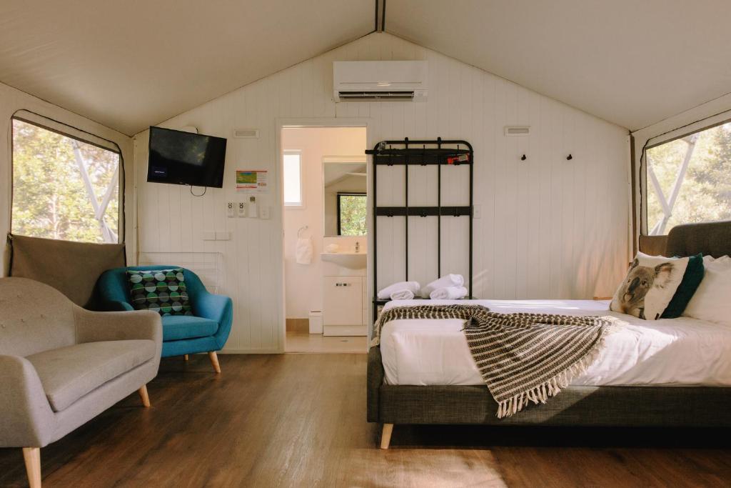 a bedroom with a bed and a chair in a room at Port Stephens Koala Sanctuary in One Mile