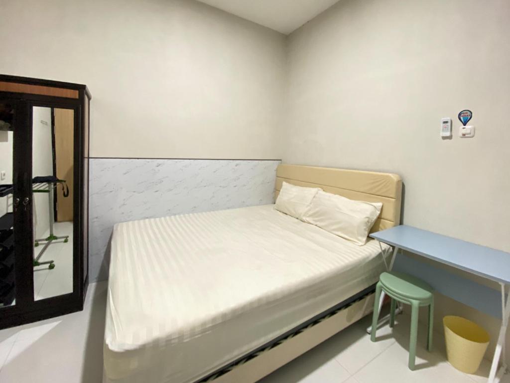 a small room with a bed and a desk at Modern Stay near Roxy Mall Jember RedPartner in Panti