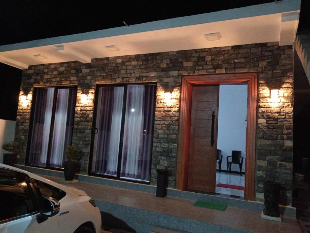 a house with three windows and a car parked in front at Biyagama Highway view Luxury House in Kelaniya