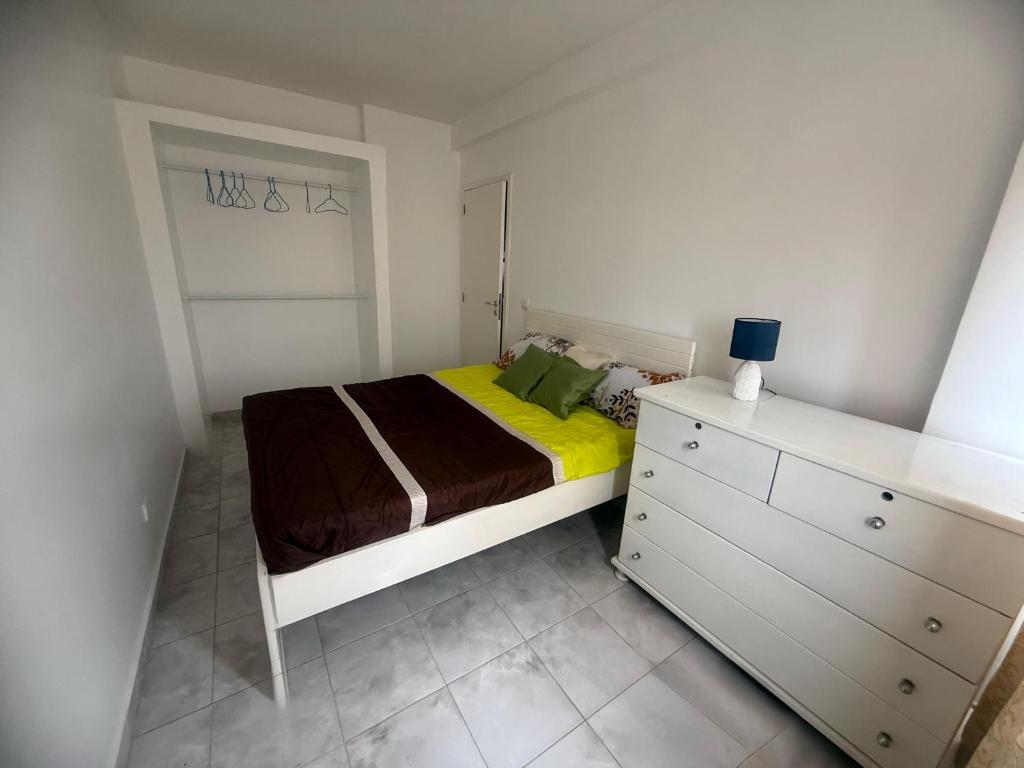 Un dormitorio pequeño con una cama y una cómoda. en Room & Breakfast Praia, en Praia