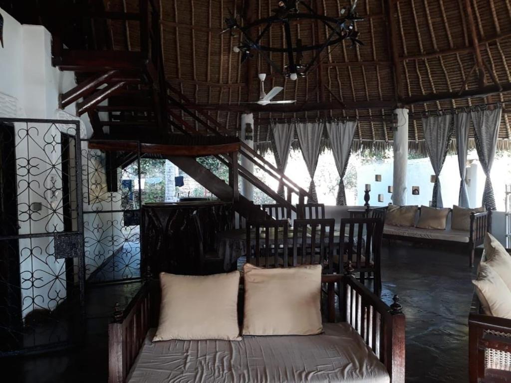 a bedroom with a bed in a room with windows at Artistic Dreamsace 4Br Villa Near Diani Beach in Kwale