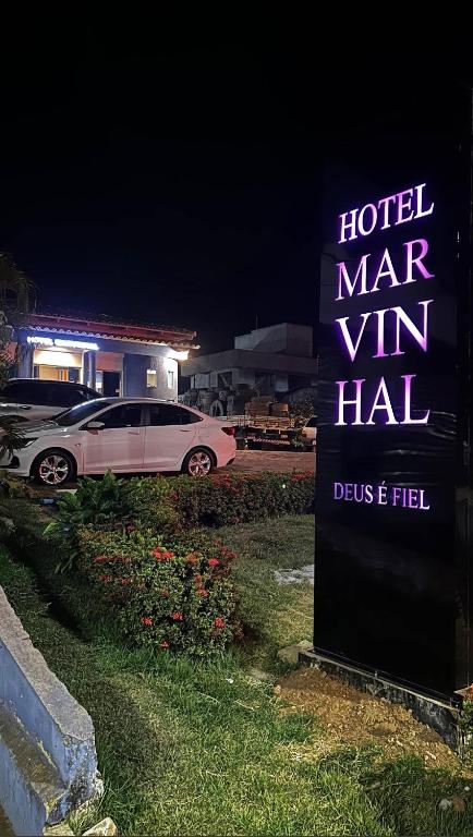 a sign for a hotel with a car parked next to it at Hotel MarVinhal in Santa Maria