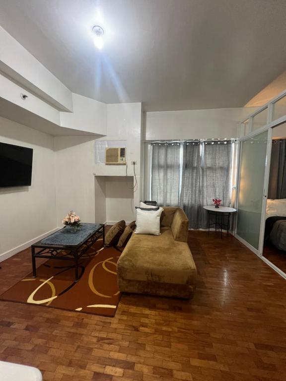 ein Wohnzimmer mit Sofa und Tisch in der Unterkunft Robinson's Place Residences, in Manila