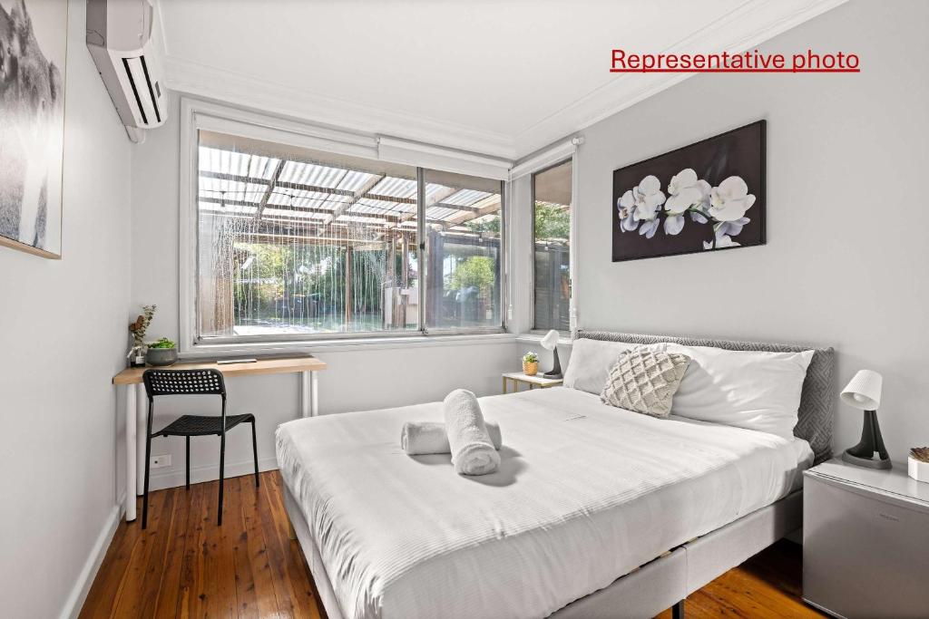 Un dormitorio con una cama y un escritorio y una ventana. en Light & Simple Double Room - Peakhurst Area - Shared Bathroom, en Peakhurst