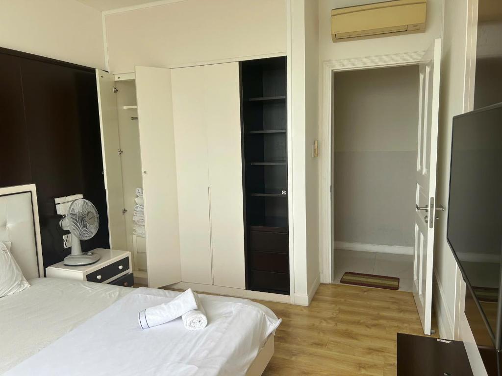 a bedroom with a white bed and a closet at Ocean Vista Resort Sealink Phan Thiet in Ấp Phú Tịnh (2)