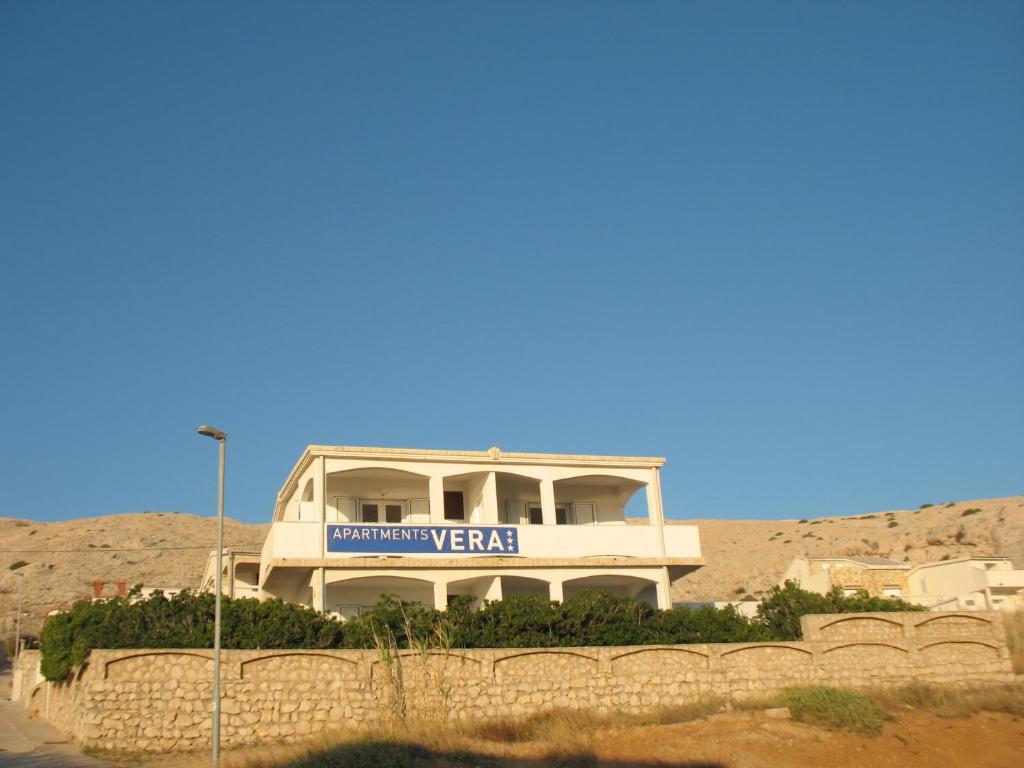 a building with a sign on top of it at Apartments Vera in Pag
