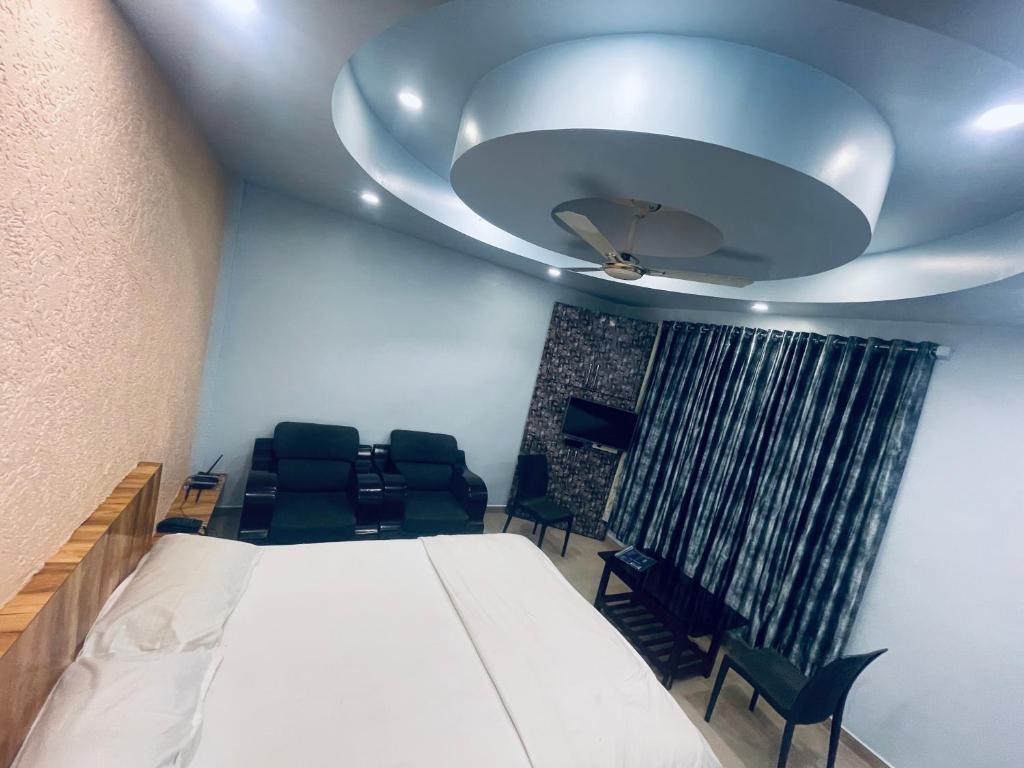 PanhālaNatural resort的配有床和椅子以及天花板的客房