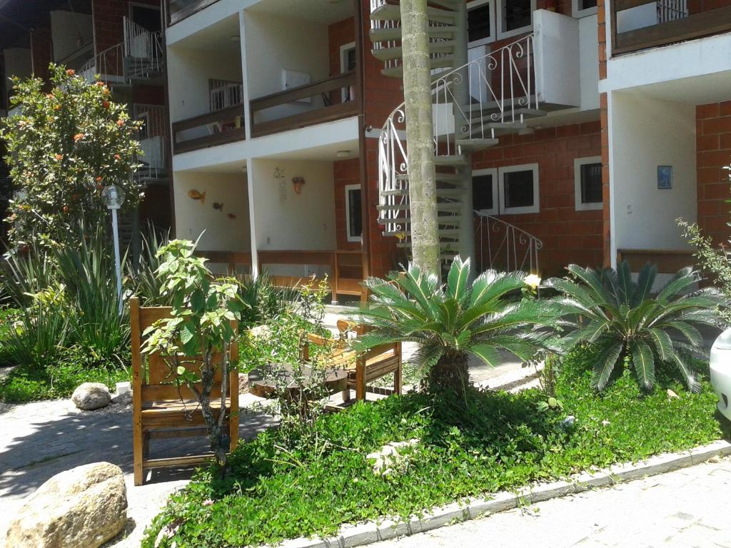 a courtyard of a apartment building with trees and plants at Apartamento 5 no Condominio Marina V in Ubatuba