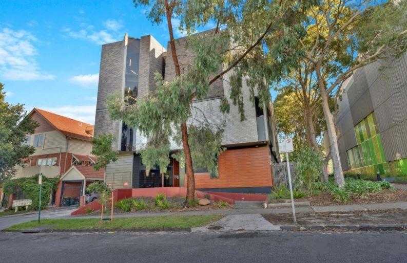 a house on a street with a street sign in front of it at One Bedroom Penthouse Apartment in the heart of Box Hill in Box Hill
