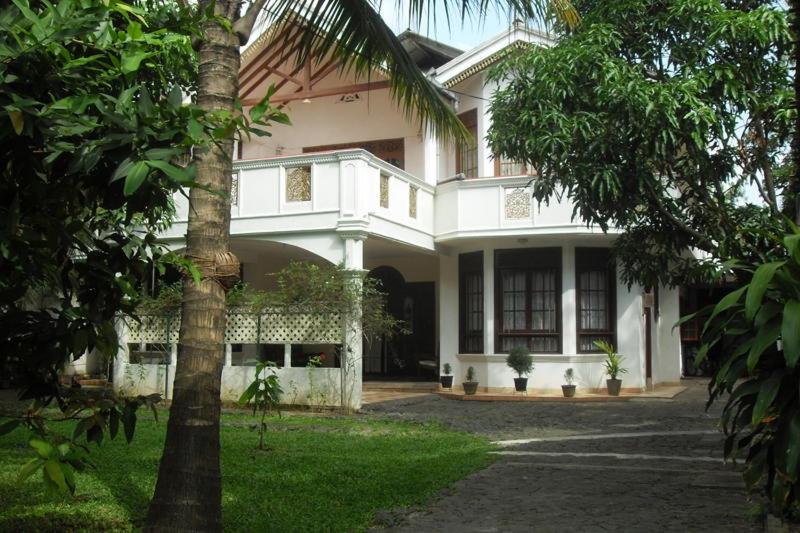 una casa blanca con una palmera delante en Martin Villa, en Matara