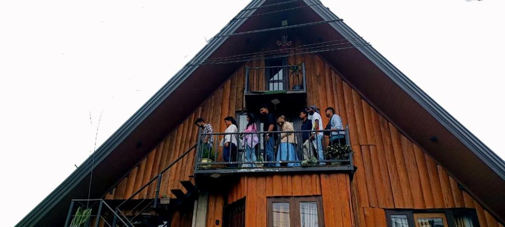 努沃勒埃利耶The Heaven Wood Cabin的一群人站在建筑物的阳台上