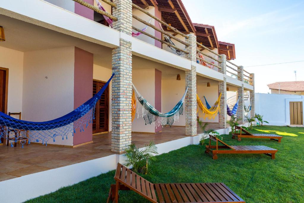 a building with hammocks on the side of it at Cumbuco Kite in Paradise e Hospedaria in Cumbuco