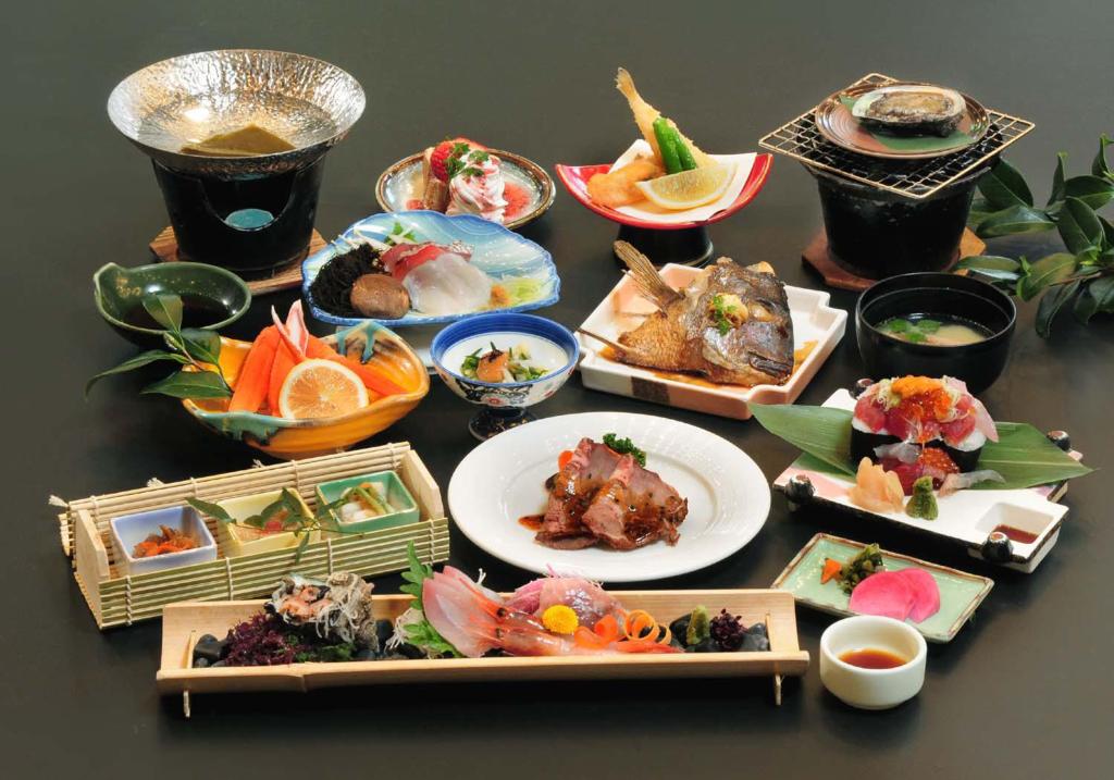 a table with many plates of food on it at Yura Onsen Yaotome in Tsuruoka