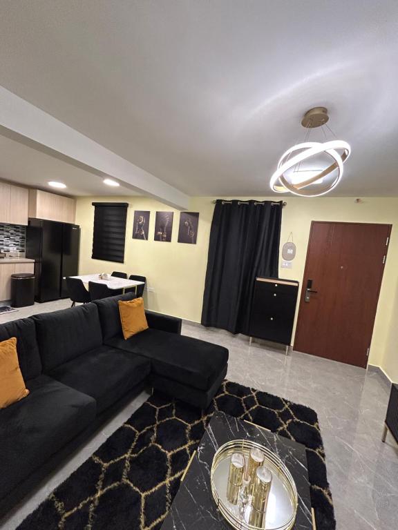 un soggiorno con un divano nero e un tavolo di Luxe Royal 1BR at the Vineyards w Pool & WiFi a Kingston