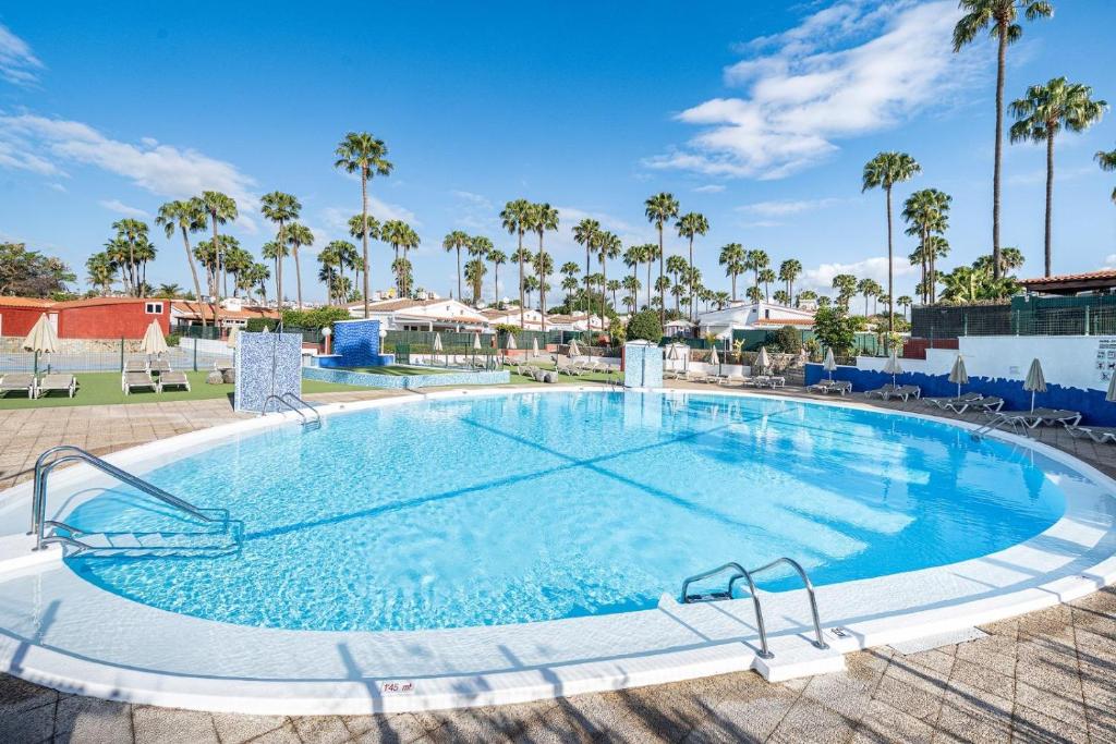 a large swimming pool in a resort with palm trees at Mar y Sol in Maspalomas