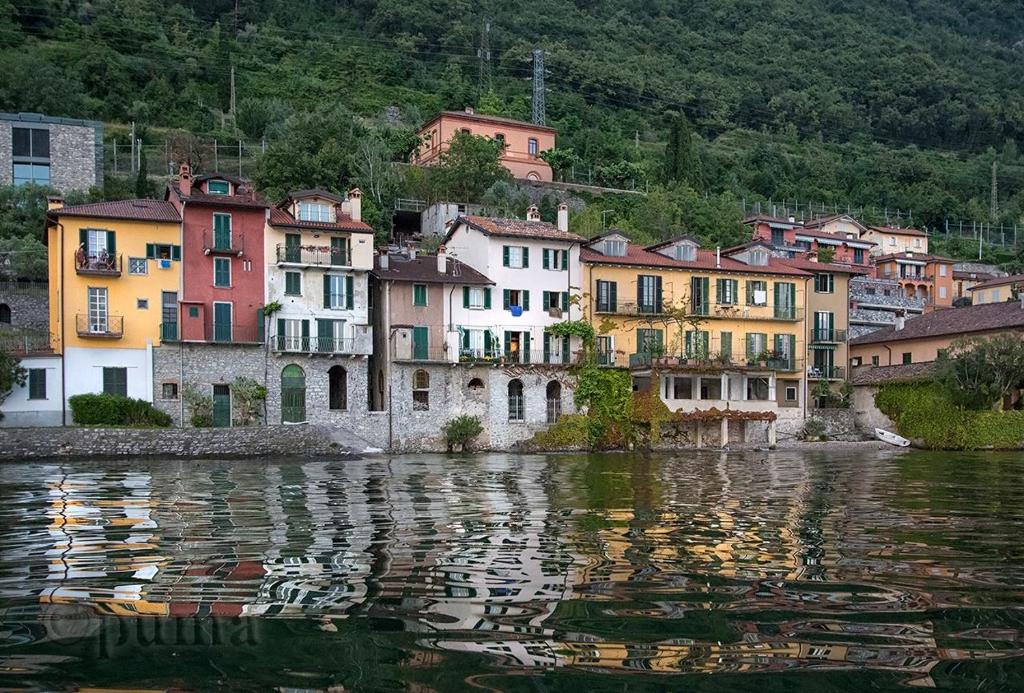 a group of houses on the shore of a body of water at Casa sullo Sperone in Varenna