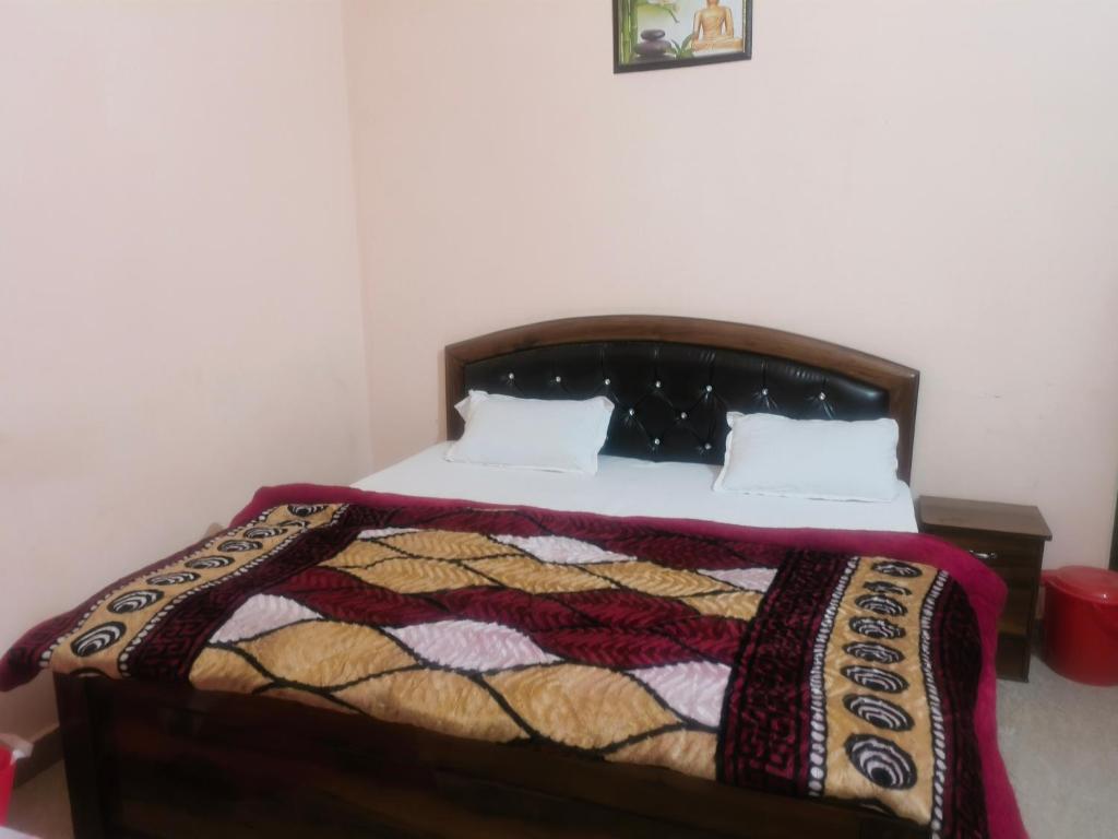 ein Schlafzimmer mit einem Bett mit einer Steppdecke darauf in der Unterkunft Shree mangalam lnn in Prayagraj