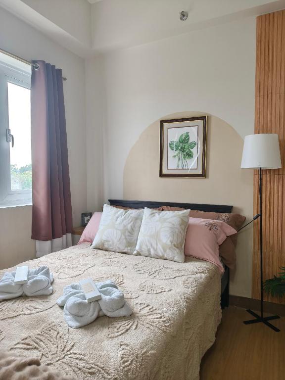 a bedroom with a bed with two towels on it at K&C Suite in Trece Martires