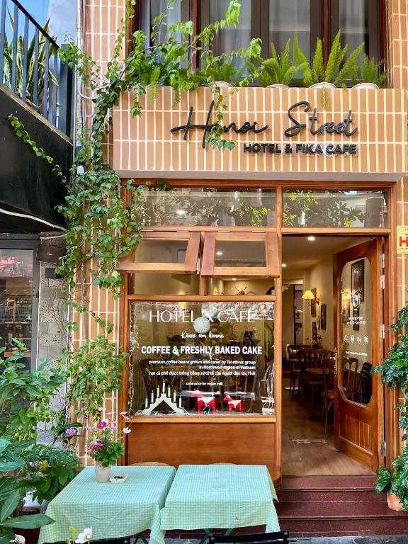 a store front with two tables in front of it at Hanoi Street Hotel in Hanoi