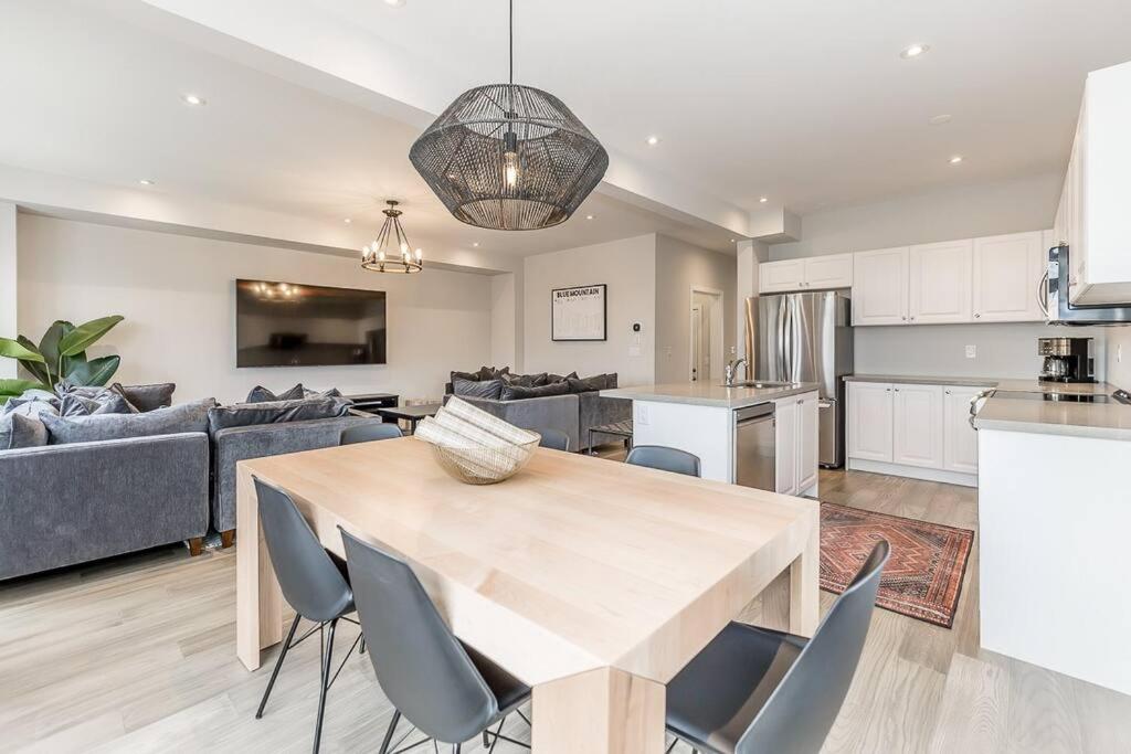 eine Küche und ein Wohnzimmer mit einem Holztisch und Stühlen in der Unterkunft Modern Luxury Townhome Walk to Blue Shuttle in Blue Mountains