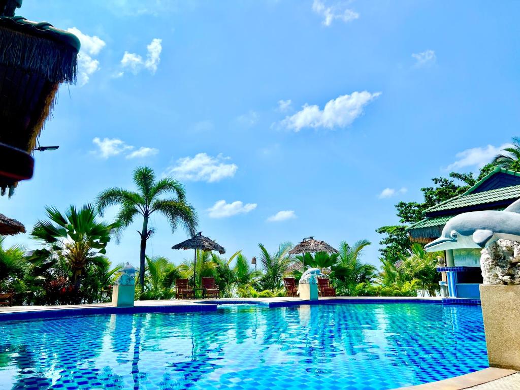 uma piscina em um resort com palmeiras em Sense Asia em Haad Tian