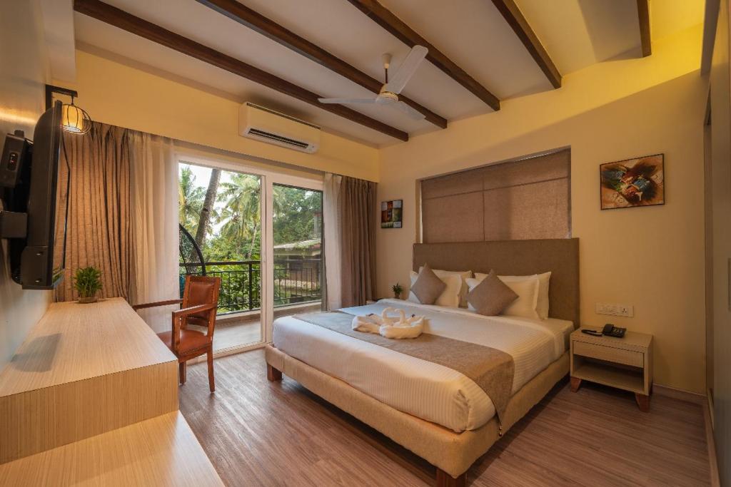 a bedroom with a large bed and a window at Luxury Retreat Evoke 2Bhk Apts in Candolim