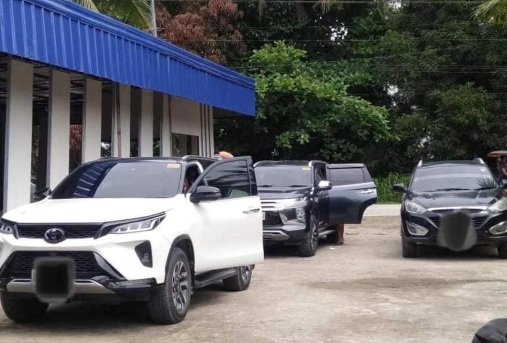 eine Gruppe von Autos, die auf einem Parkplatz geparkt sind in der Unterkunft KrizLion Hotel in Hinatuan