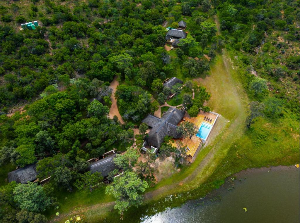 an aerial view of a house with trees and water at Ilanga Lodge Welgevonden Game Reserve in Welgevonden Game Reserve