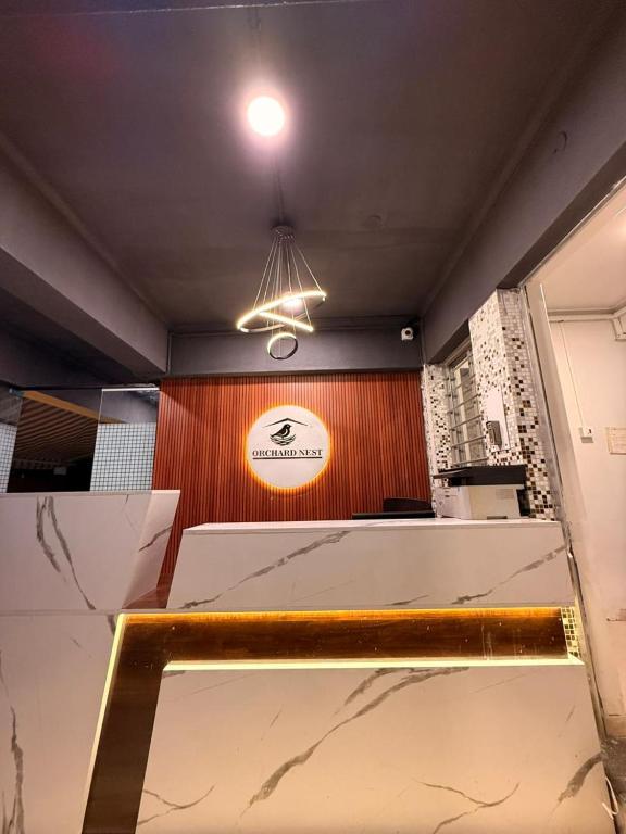 a room with a table and a sign on a wall at Hotel Orchard Nest - Pune Sinhgad Road in Pune