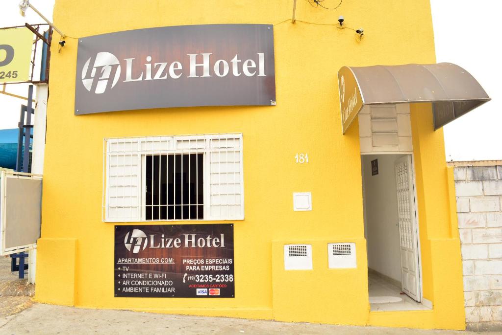 um edifício amarelo com um sinal na lateral em Lize Hotel em Campinas
