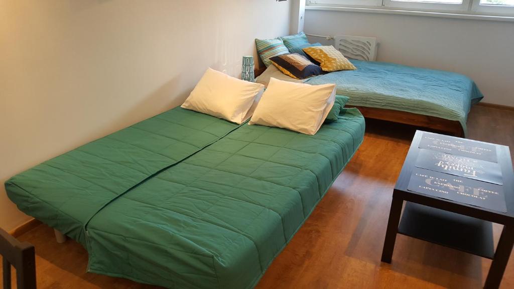 ヴロツワフにあるPod Mostem 2のベッド2台 緑のソファ付きの部屋