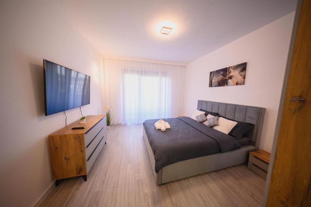 ein Schlafzimmer mit Bett und Flachbildfernseher in der Unterkunft Malvina Apartments Cazare Mures in Târgu Mureș