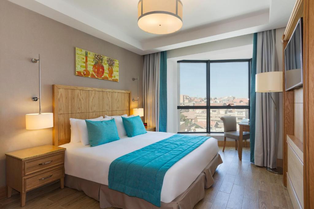 pokój hotelowy z łóżkiem i dużym oknem w obiekcie Hotel Setif Plus w Satif