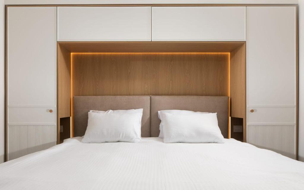 a bed with white sheets and white pillows at Sweet Sea Side Eilat - סוויט סי סייד, אילת in Eilat