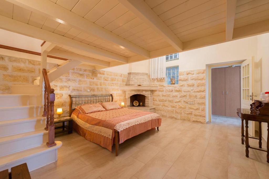Theologos Traditional House في ثيولوغيس: غرفة نوم بسرير في غرفة بها موقد