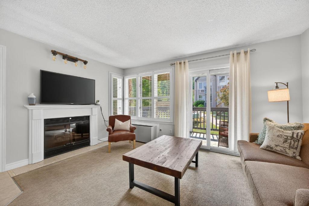 a living room with a couch and a tv at Heavenly Hideaway Ski-In-Out Pool Shuttle in Blue Mountains