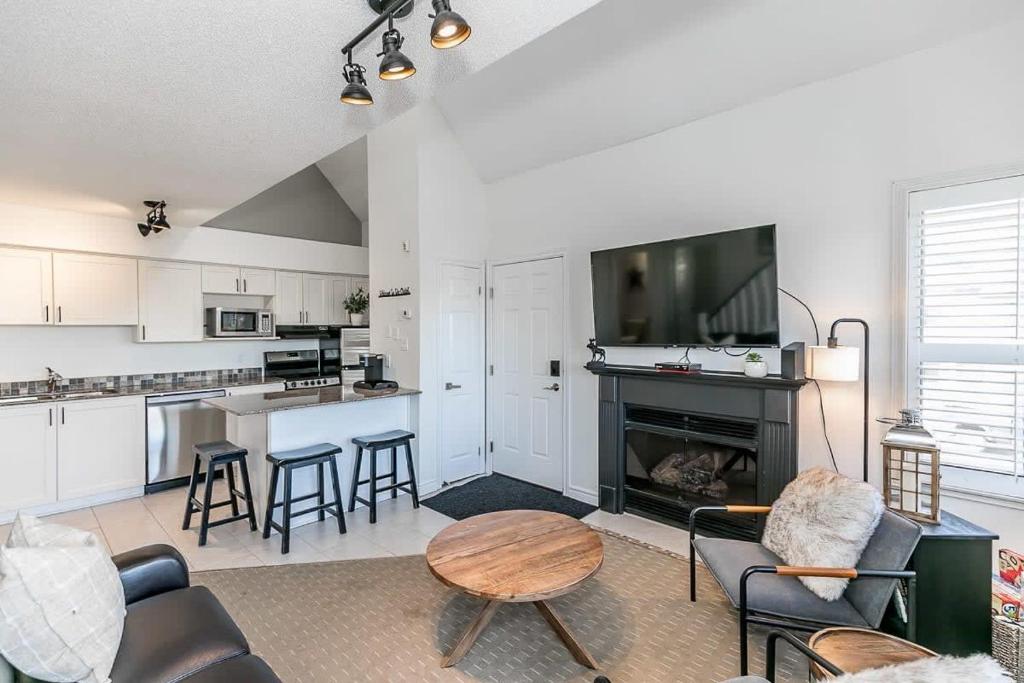 een woonkamer met een open haard en een keuken met een tafel bij Mountain Peaks Ski-In-Out Pool Shuttle in Blue Mountains