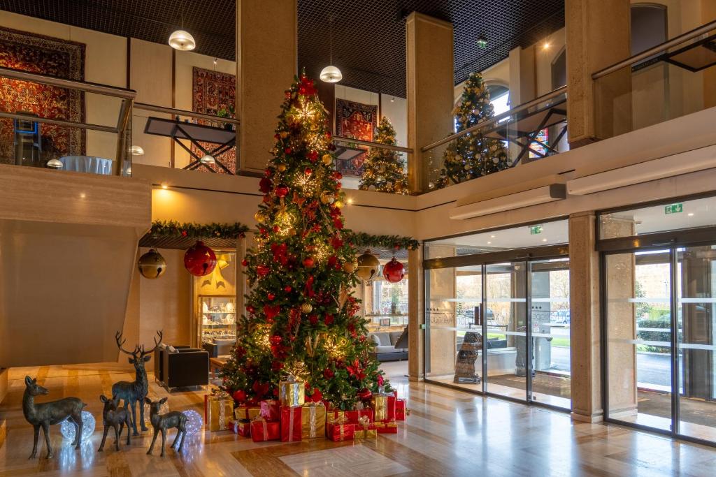 Un árbol de Navidad en medio de un edificio en Hôtel Lyon Métropole & Spa, en Lyon