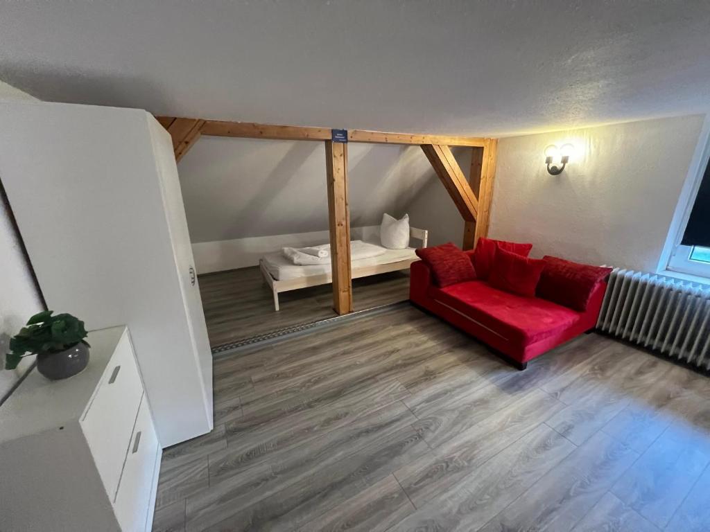 a living room with a red couch and a bed at Basic Monteurzimmer Work & Stay in Kempten