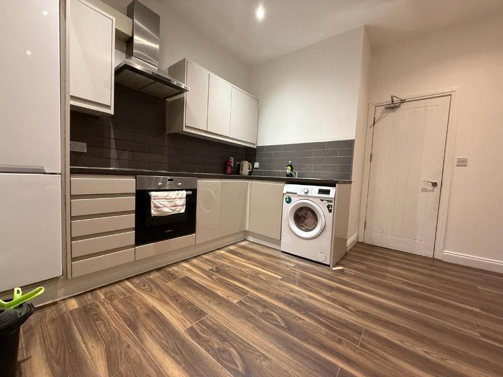 a kitchen with a washing machine and a washer at Belin Stay in Hackbridge