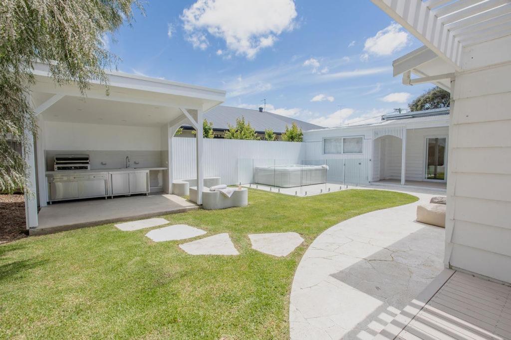 Coastal Waters - Spa, Sleeps 8, Newly Renovated في أوشن غروف: حديقة خلفية لبيت أبيض مع حديقة