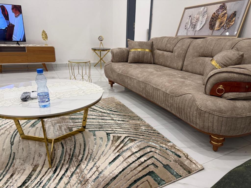 un soggiorno con un divano e un tavolo di Le Prestige Appartement à Oloumi a Libreville