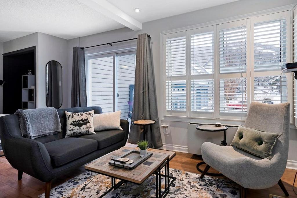 een woonkamer met een bank en een stoel bij Mountainside Escape Ski-In-Out Pool Shuttle in Blue Mountains