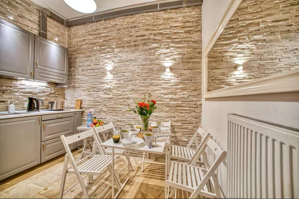 a kitchen with a table and chairs and a brick wall at Saroko Apartment 1 in Ágios Rókkos