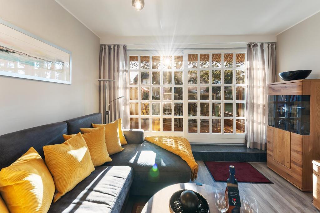 un salon avec un canapé et une fenêtre dans l'établissement Hüs Swarte Wall, à Kampen