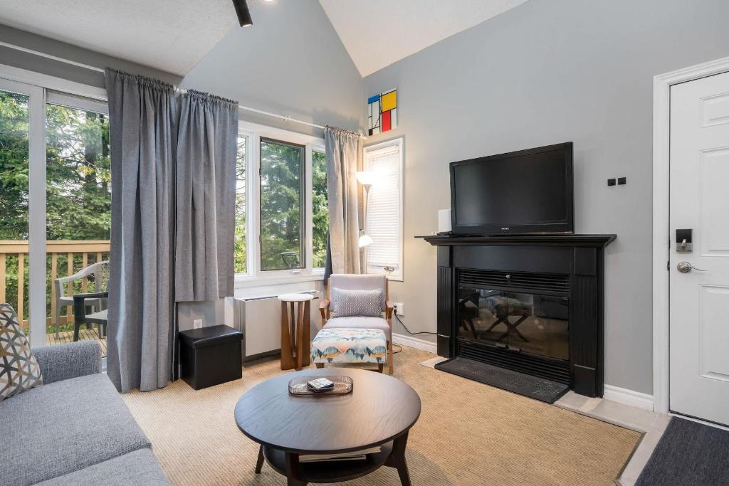 un salon avec une cheminée et une télévision dans l'établissement Blue Haven Ski-In-Out Pool Hot Tub Shuttle, à Blue Mountains