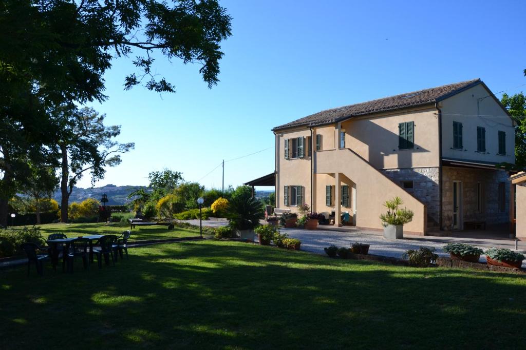 uma casa grande com um jardim de relva ao lado de um edifício em Il Mandorlo - Agriturismo e Azienda Agricola Ferrato em Ancona