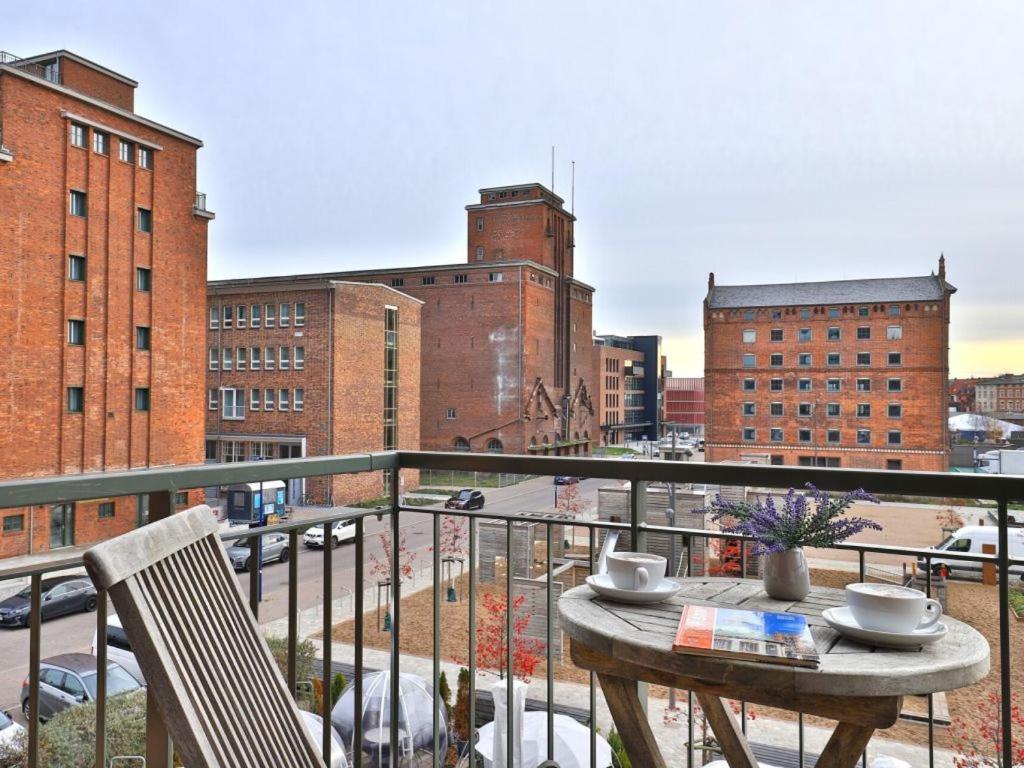 stół i krzesła na balkonie z widokiem na miasto w obiekcie Ohlerich Speicher App_ 10 w mieście Wismar