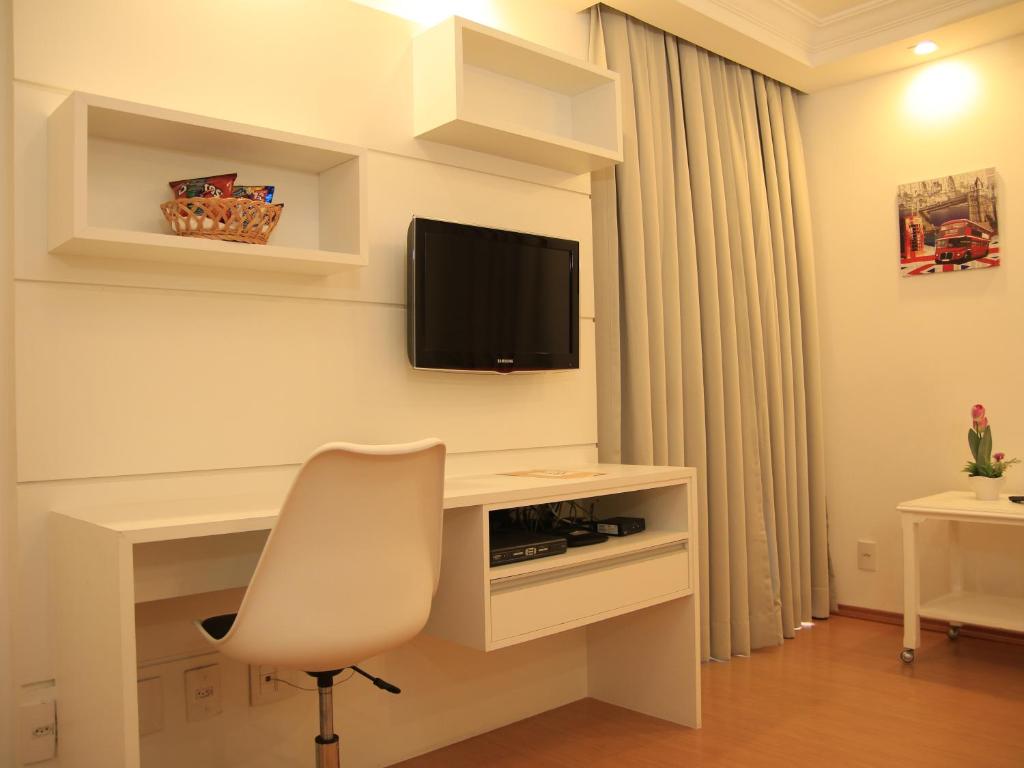 um quarto com uma secretária com uma cadeira e uma televisão em The Park Hall Flat Service Higienópolis em São Paulo