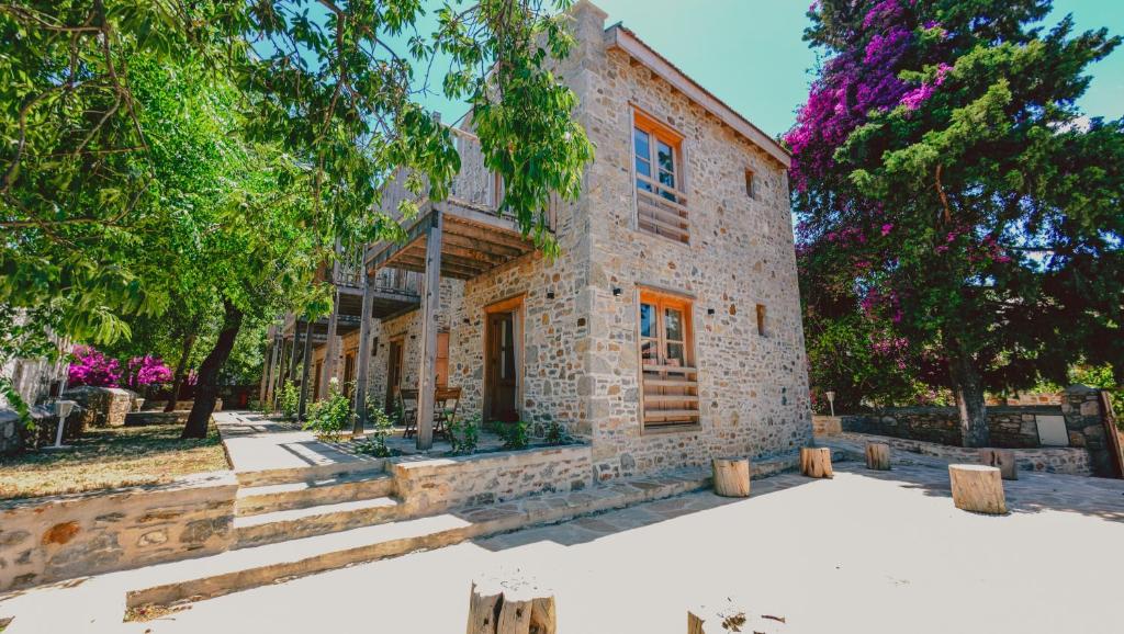 an exterior view of a stone house with trees at Gulhiz in Datca